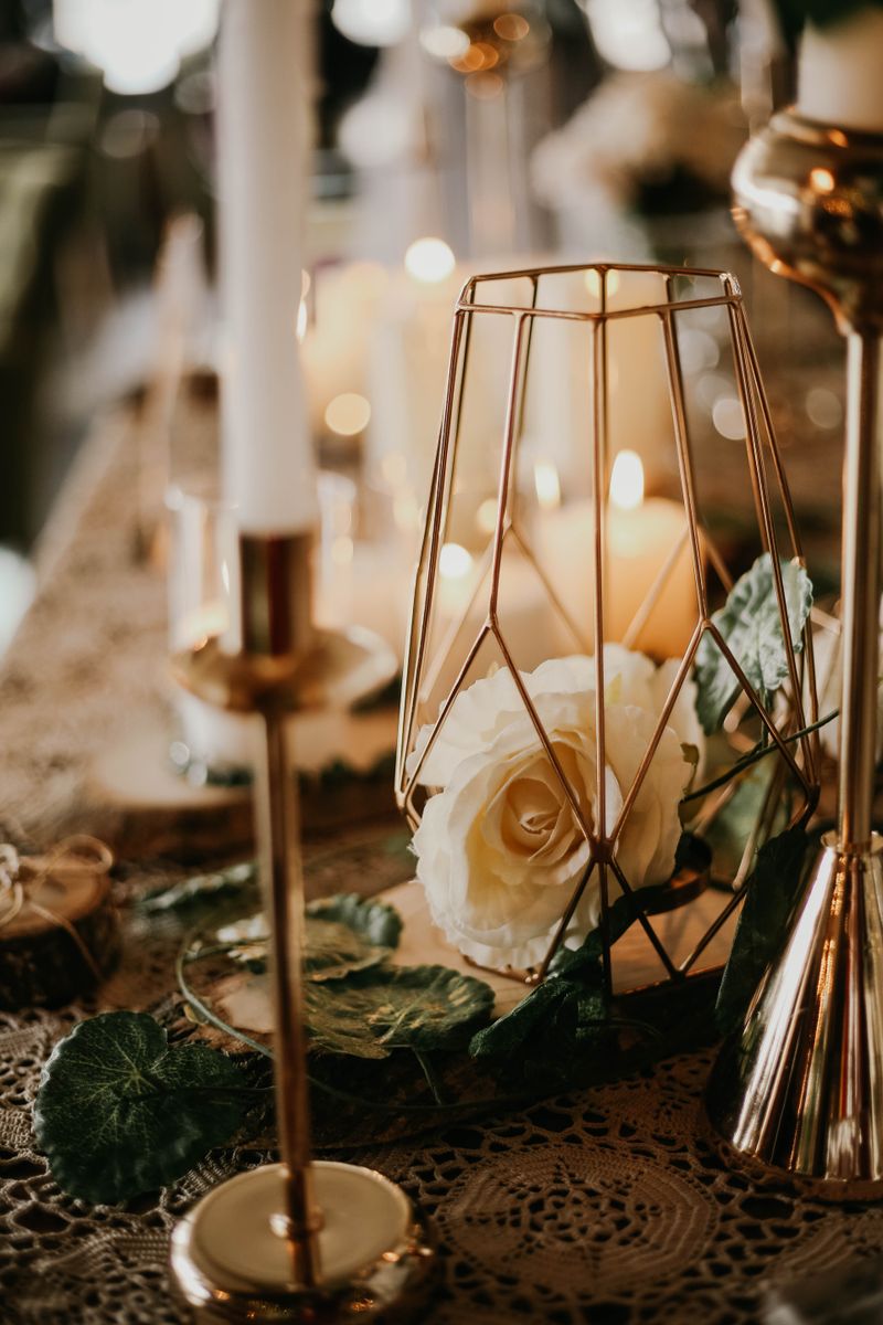 A wedding table set with candles and white roses